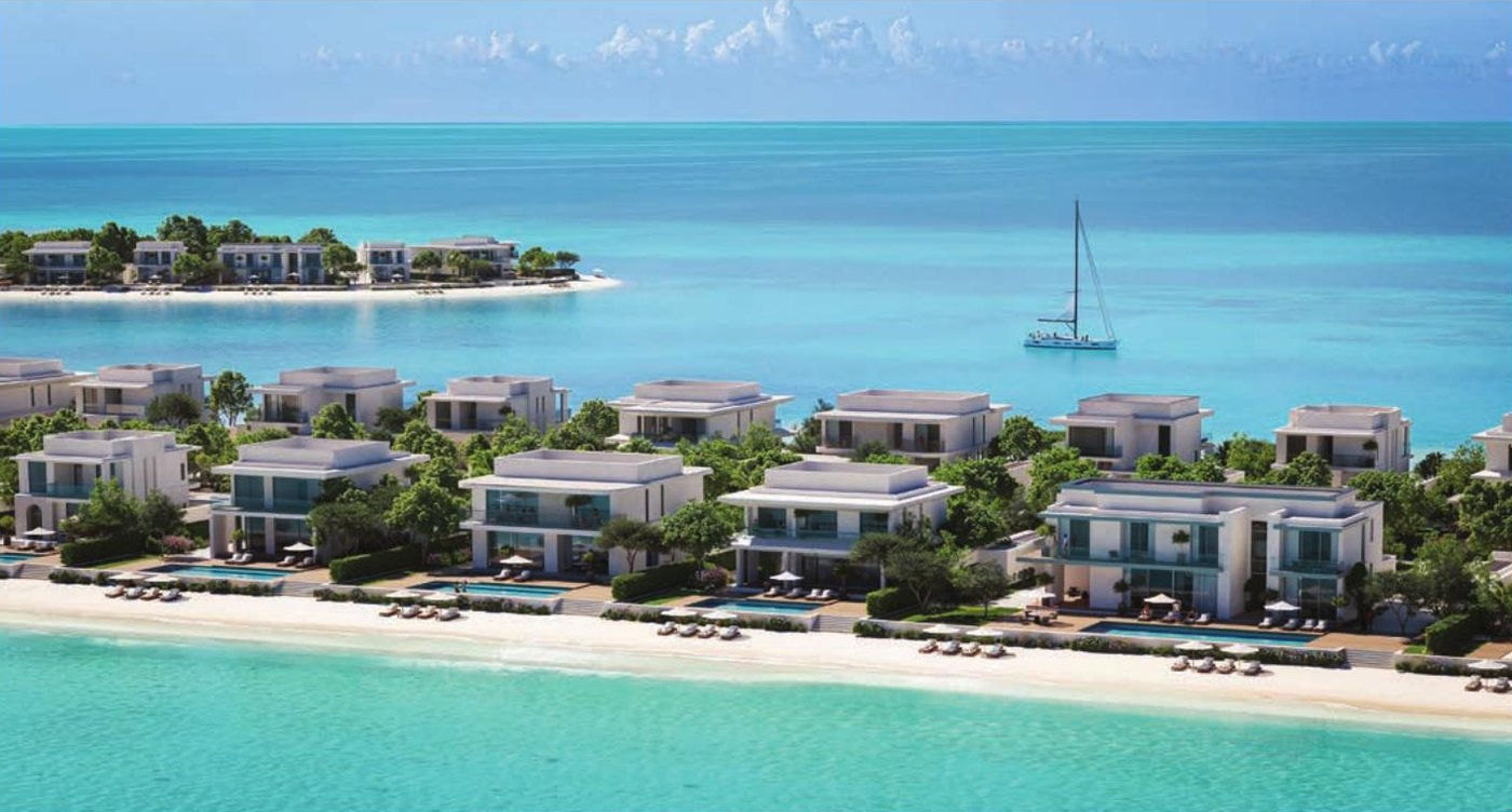 An aerial view of waterfront villas along a white beach at Ramhan Island