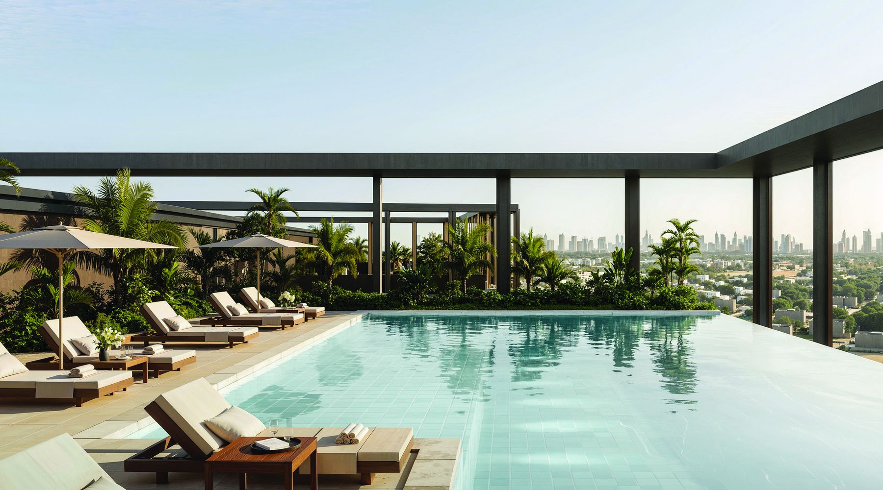 The rooftop pool at The Archive, with loungers, shaded seating and planting above the city