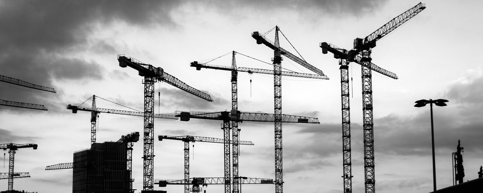Residential towers under construction with tower cranes, in black and white